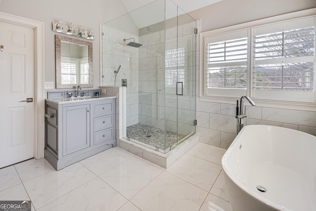 bathroom featuring vanity, a shower stall, a soaking tub, and marble finish floor