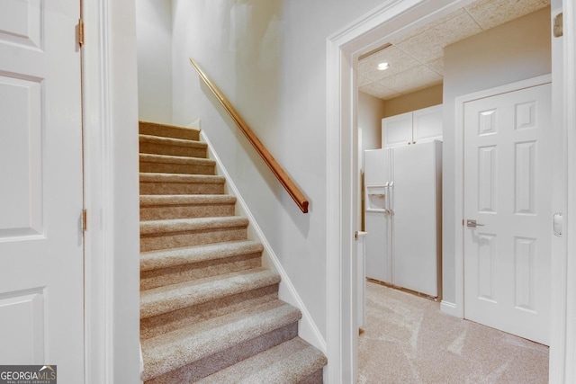 stairs with recessed lighting, baseboards, and a drop ceiling