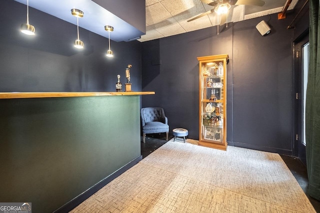 bar featuring a ceiling fan and baseboards