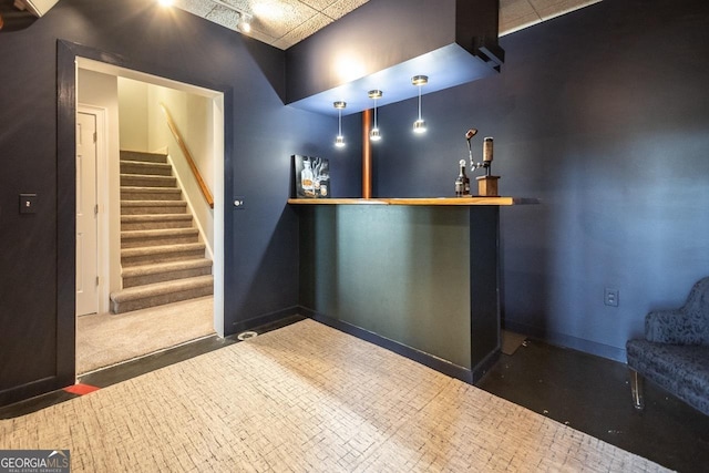 bar with a dry bar, stairs, and baseboards