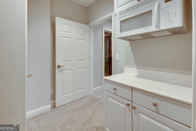 interior space with light colored carpet and baseboards