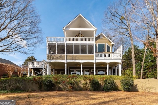 rear view of house with a balcony and a sunroom