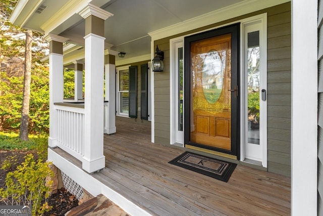 entrance to property featuring visible vents and covered porch