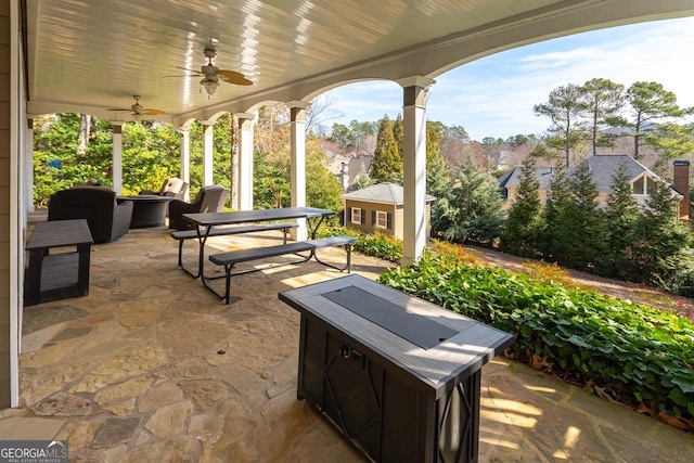 view of patio featuring outdoor dining space, an outdoor structure, and ceiling fan