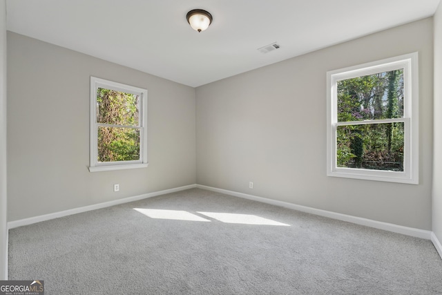 spare room featuring visible vents, baseboards, and carpet