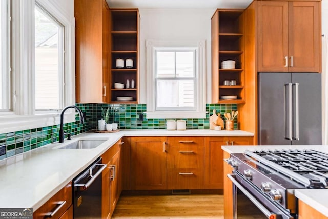 kitchen featuring open shelves, high end appliances, brown cabinetry, and a sink