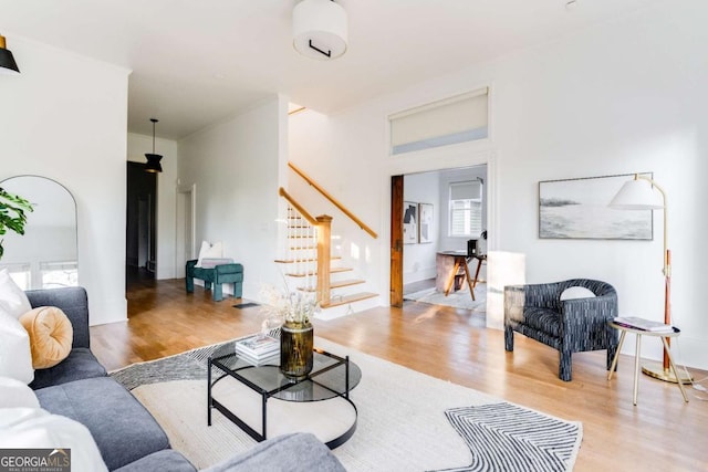 living area featuring stairs, wood finished floors, visible vents, and a healthy amount of sunlight