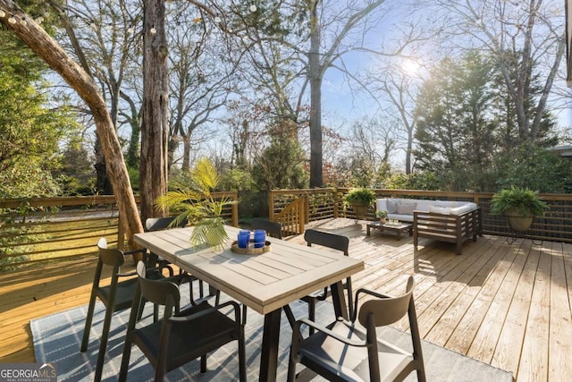 wooden terrace with outdoor dining space and an outdoor living space