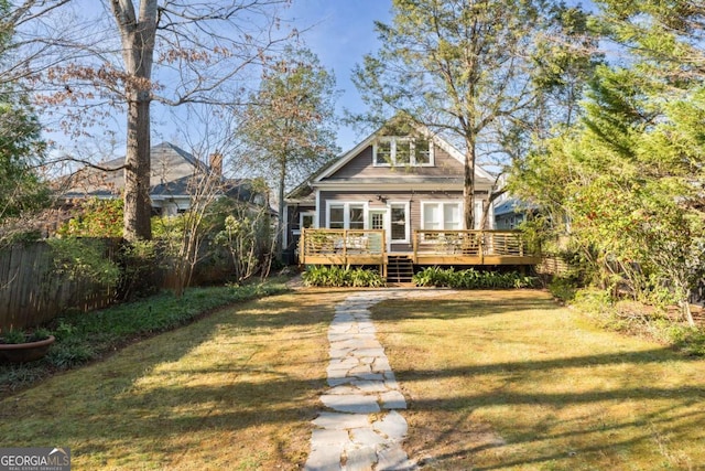 back of property with a deck, ceiling fan, a yard, and fence