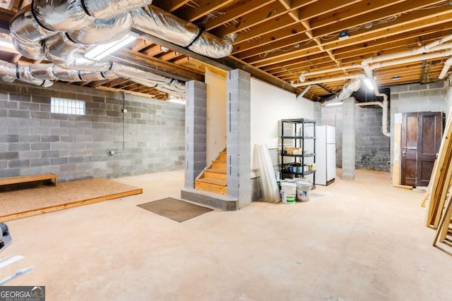 unfinished below grade area with stairway and freestanding refrigerator