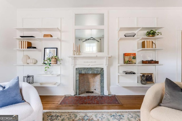 living area with a high end fireplace and wood finished floors