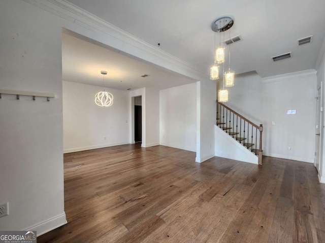 unfurnished living room featuring stairway, visible vents, wood-type flooring, and ornamental molding