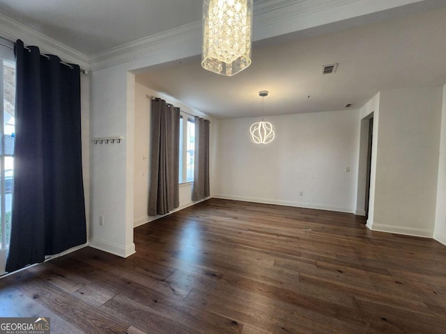 spare room featuring visible vents, crown molding, baseboards, dark wood finished floors, and an inviting chandelier