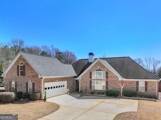 traditional-style home featuring concrete driveway, brick siding, a garage, and a chimney