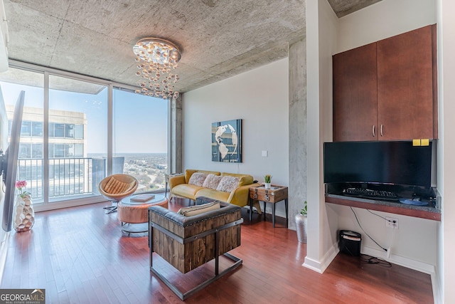 living room with an inviting chandelier, wood finished floors, baseboards, and expansive windows