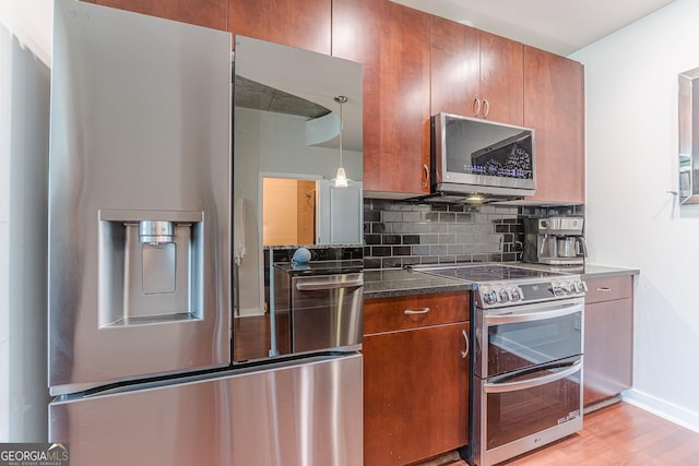 kitchen featuring backsplash, light wood-style floors, brown cabinets, and appliances with stainless steel finishes