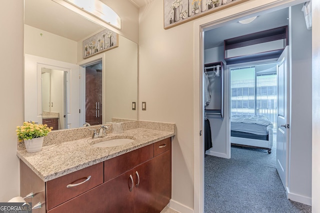 ensuite bathroom with vanity, baseboards, and connected bathroom