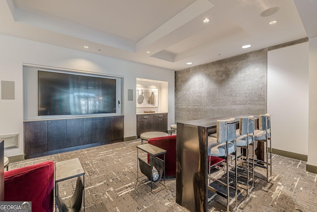 interior space featuring a tray ceiling, recessed lighting, and baseboards