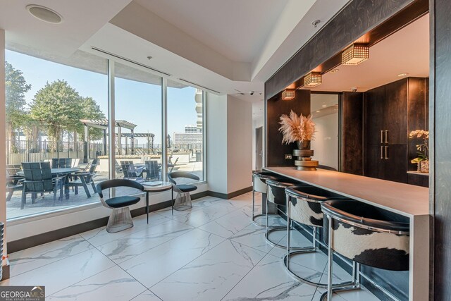 bar with a city view, baseboards, and marble finish floor