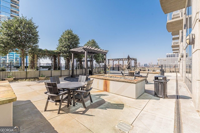 view of patio featuring fence, outdoor dining space, and a pergola