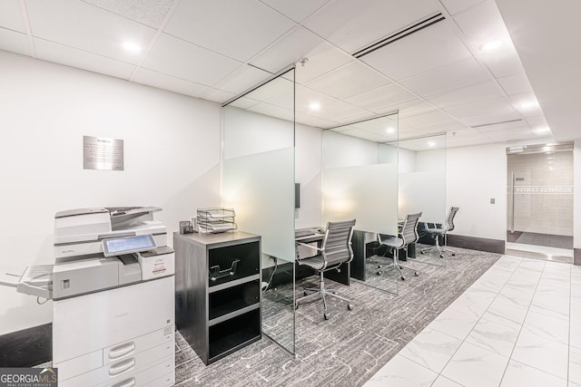 office area featuring visible vents, a paneled ceiling, and marble finish floor