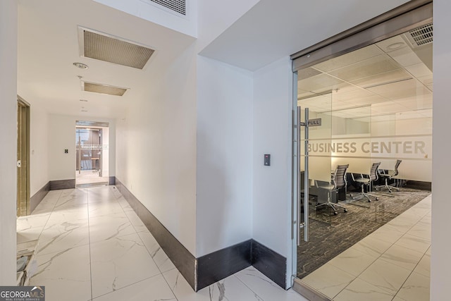 corridor with visible vents, marble finish floor, and baseboards