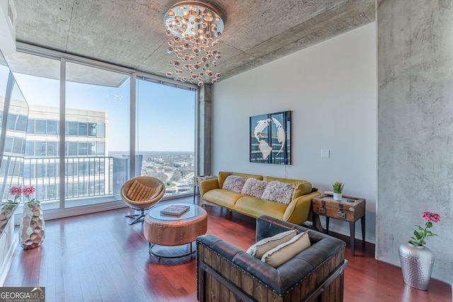 living room featuring an inviting chandelier, a wall of windows, and wood finished floors