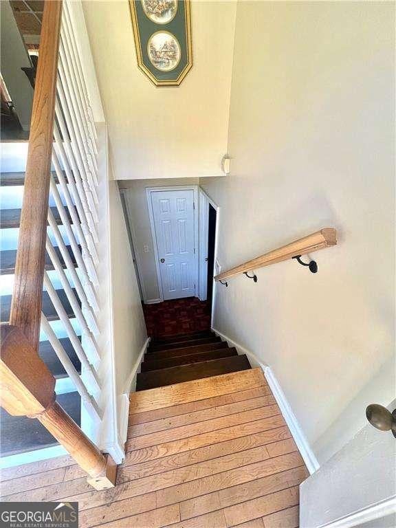 3672 Misty Oak Dr, Flowery Branch, GA 30542 - stairway featuring hardwood / wood-style floors and baseboards