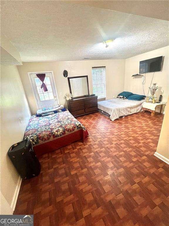 3672 Misty Oak Dr, Flowery Branch, GA 30542 - bedroom with a textured ceiling and multiple windows