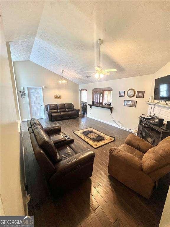 3672 Misty Oak Dr, Flowery Branch, GA 30542 - living room with a textured ceiling, vaulted ceiling, wood-type flooring, and a ceiling fan