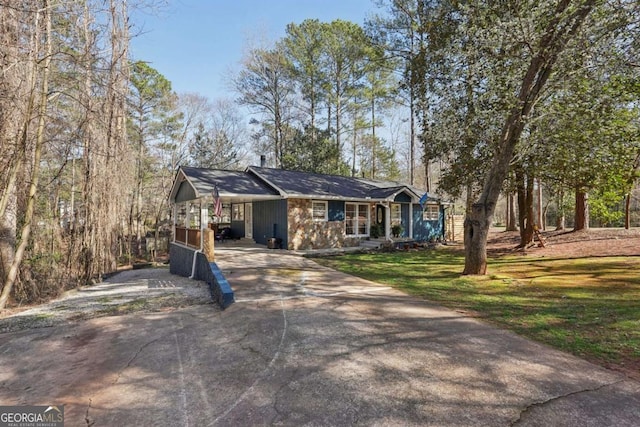 view of front of property featuring an attached carport, a front lawn, and driveway