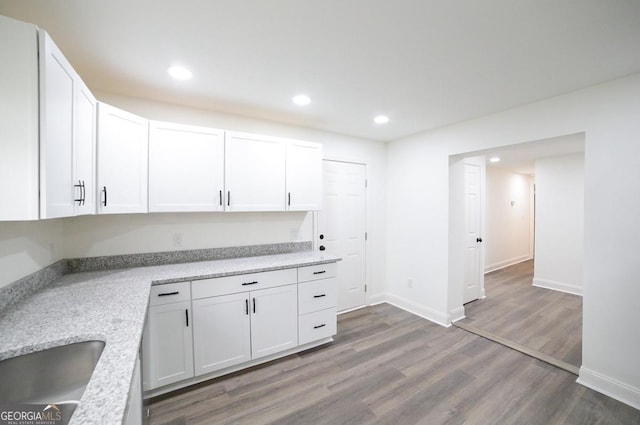 kitchen featuring white cabinetry, recessed lighting, wood finished floors, and a sink