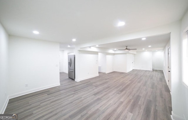 basement featuring recessed lighting, baseboards, wood finished floors, and stainless steel refrigerator with ice dispenser