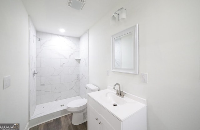 full bath featuring visible vents, wood finished floors, toilet, and a stall shower