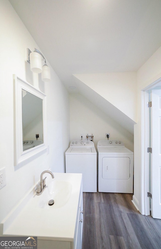 laundry room featuring washer and clothes dryer, laundry area, dark wood-type flooring, and a sink