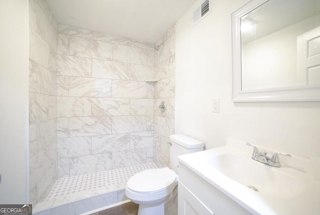 bathroom with visible vents, a stall shower, toilet, and vanity