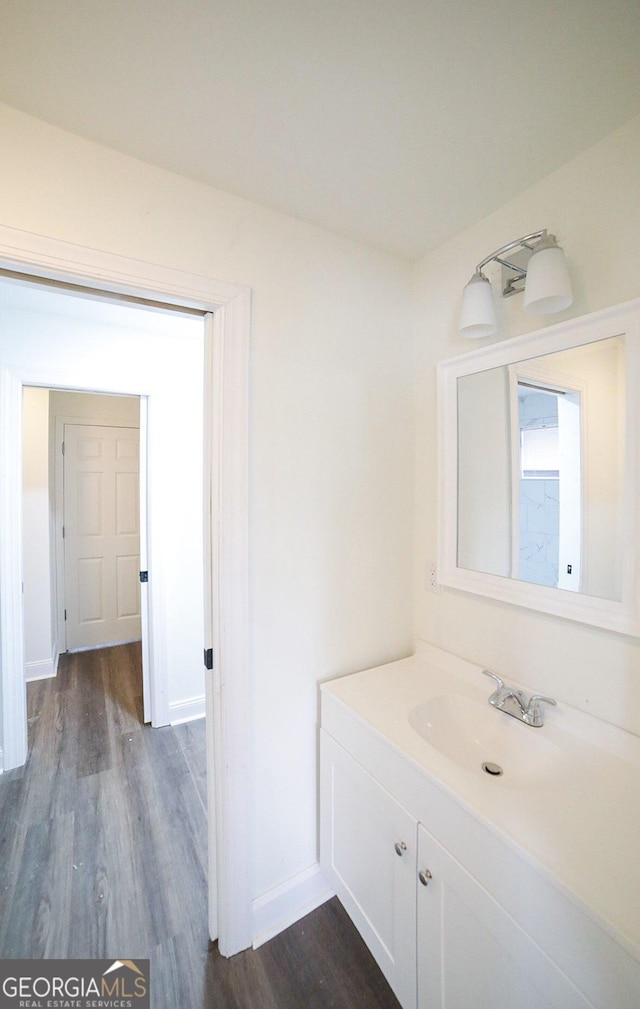 bathroom featuring vanity, baseboards, and wood finished floors