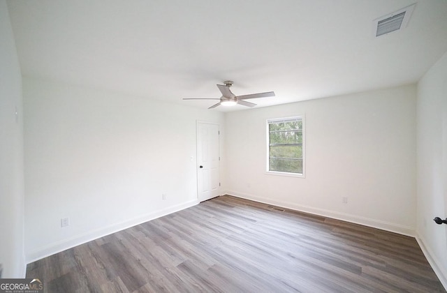 unfurnished room featuring visible vents, ceiling fan, dark wood-type flooring, and baseboards