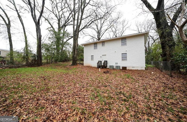 rear view of property with crawl space, central air condition unit, and fence