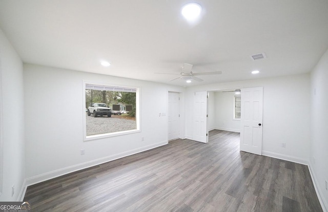 empty room featuring a ceiling fan, visible vents, baseboards, recessed lighting, and dark wood-style flooring