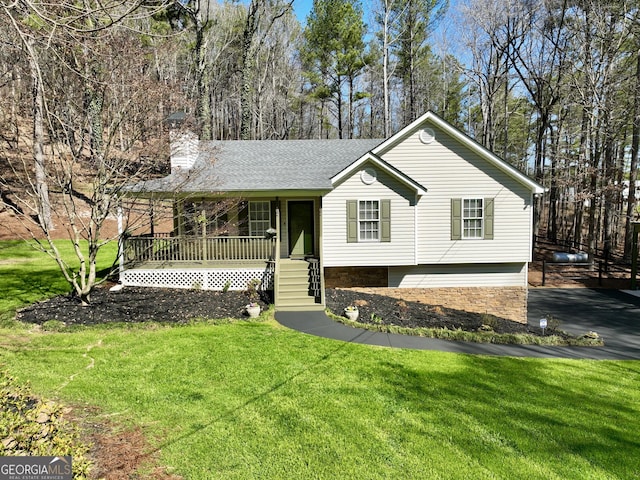 view of front of property featuring a shingled roof, a porch, a front yard, and a chimney