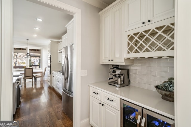 kitchen featuring tasteful backsplash, wine cooler, light countertops, stainless steel appliances, and white cabinetry