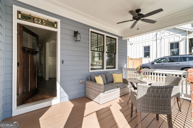 wooden terrace featuring outdoor lounge area, a porch, and a ceiling fan