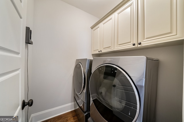 laundry room featuring cabinet space, washing machine and dryer, baseboards, and dark wood-style flooring