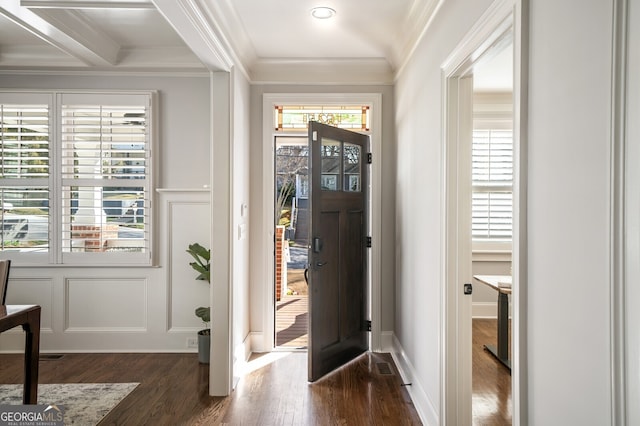 entrance foyer with a decorative wall, dark wood-style floors, and ornamental molding