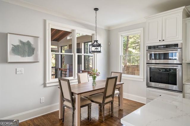 dining room with baseboards, ornamental molding, and dark wood-style flooring