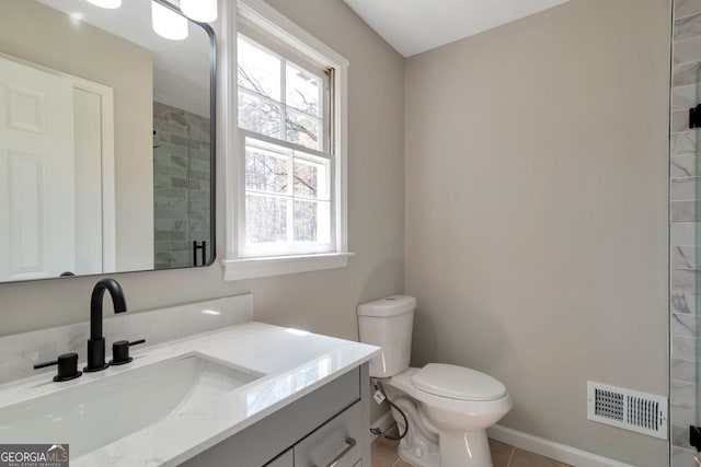bathroom featuring vanity, visible vents, tiled shower, tile patterned floors, and toilet