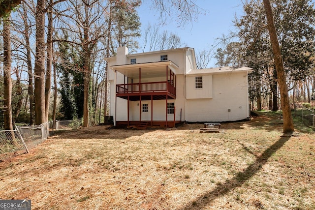rear view of property with a yard, a wooden deck, a chimney, and a fenced backyard