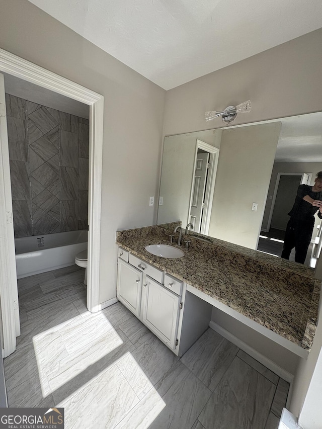 full bathroom featuring vanity, toilet, baseboards, and shower / washtub combination