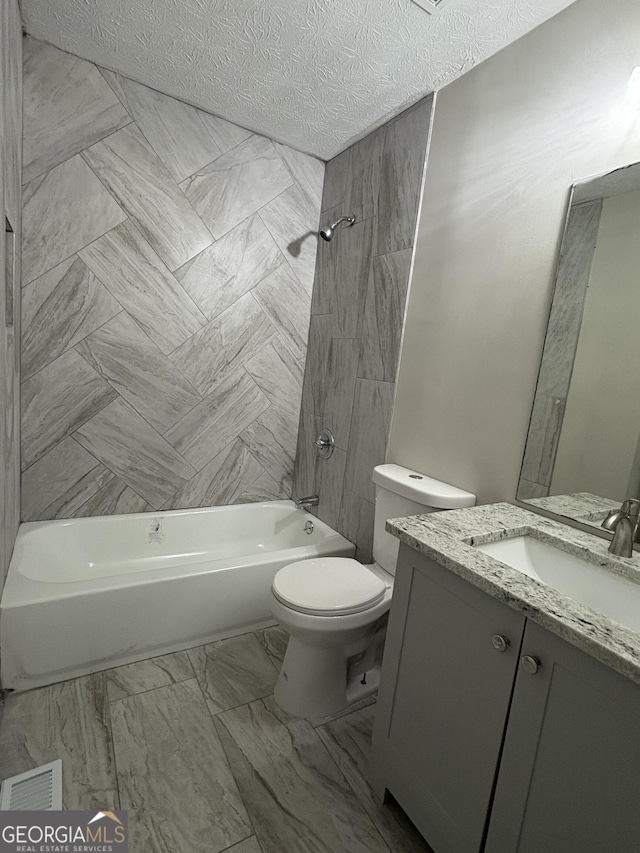 full bath with washtub / shower combination, toilet, vanity, marble finish floor, and a textured ceiling